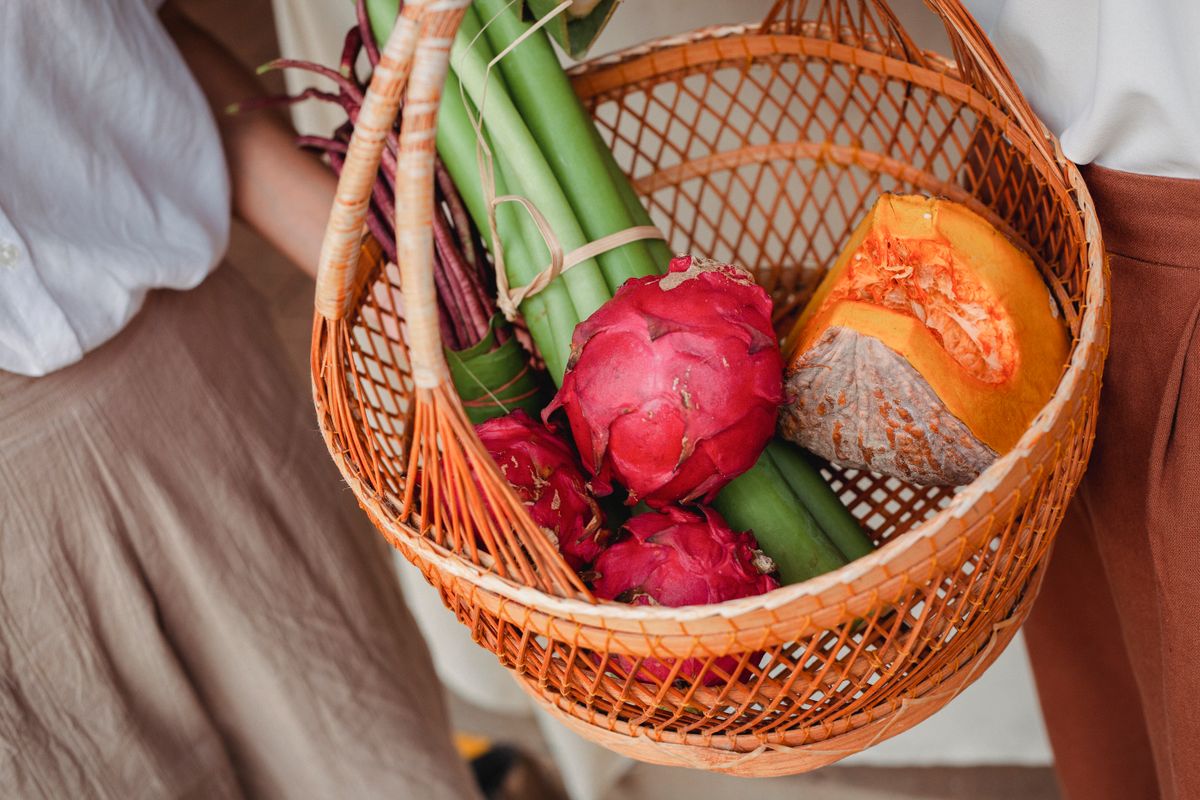 A basket of tropical fruit and fresh vegetables